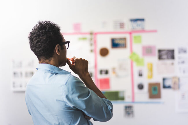 New entrepreneur planning business strategy and avoiding common startup mistakes with wall of notes